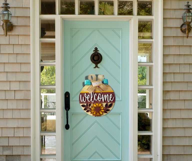 A home decor door hanger with a colorful bow that says "Welcome" hanging on a home door.