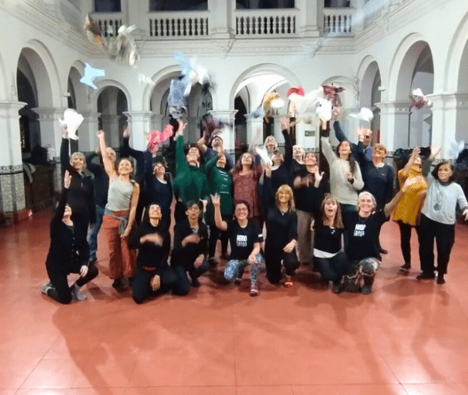 Estudiantes de Noelia sonriendo y lanzando pañuelos al aire al finalizar la clase