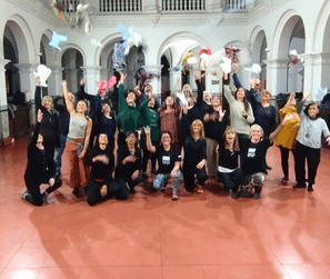 Estudiantes de Noelia sonriendo y lanzando pañuelos al aire al finalizar la clase