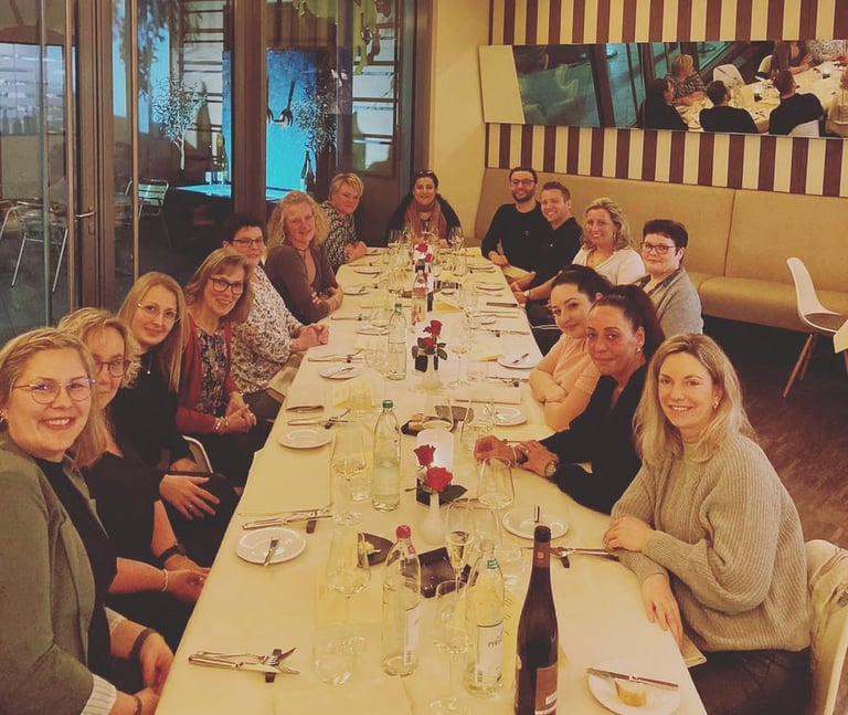 a group of people sitting at a long table
