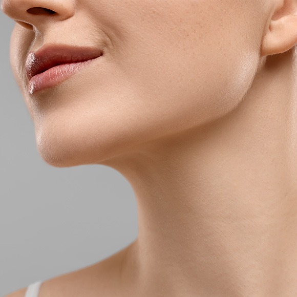 Close-up of a woman's lower face, showing a defined jawline and neck.
