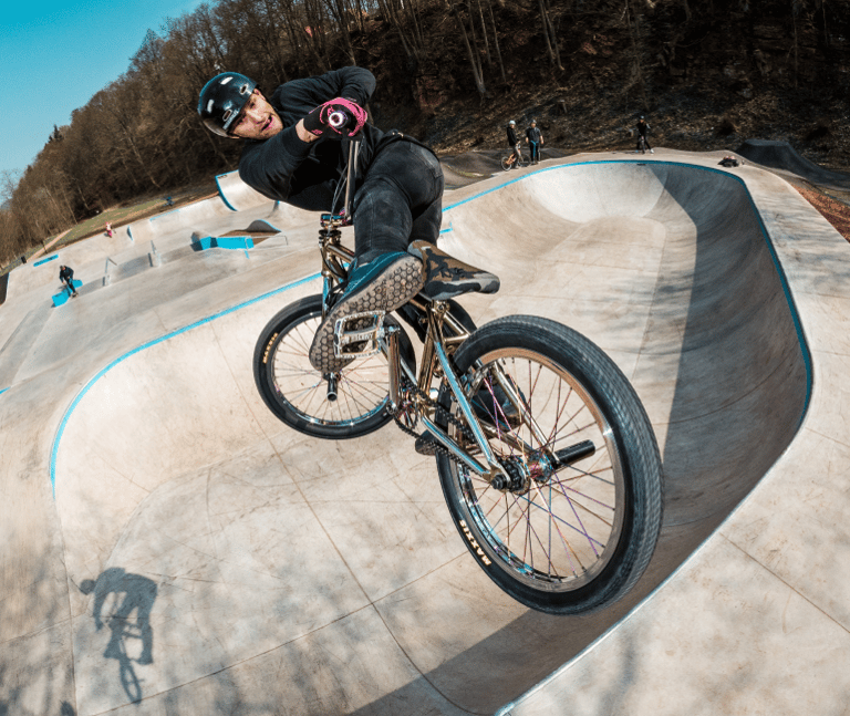 a man riding a bike on a ramp in a skate park
