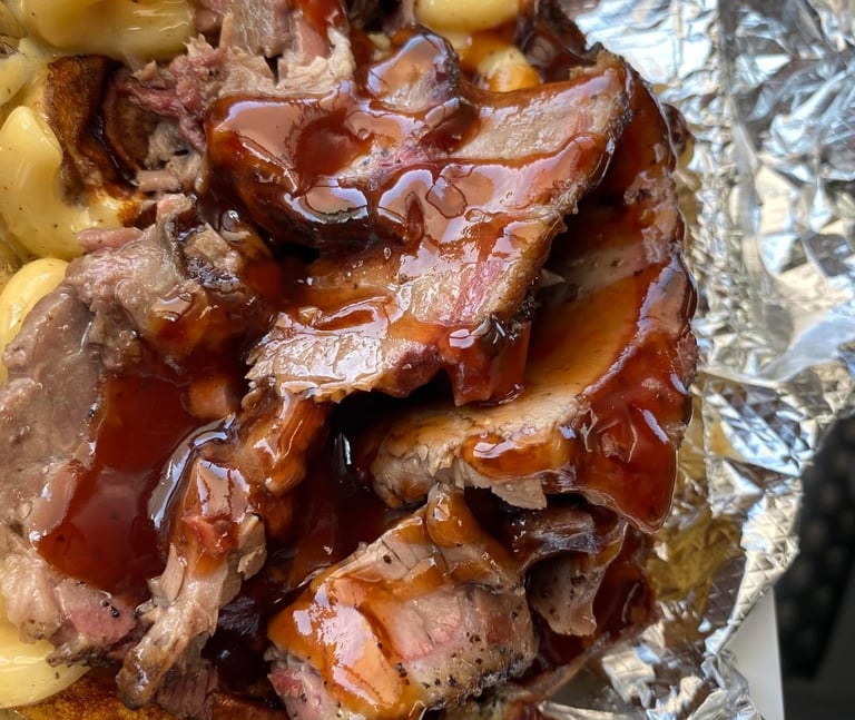 Signature One Eye Willy brisket mac and cheese—Texas-style smoked brisket over four-cheese macaroni with BBQ drizzle, served 