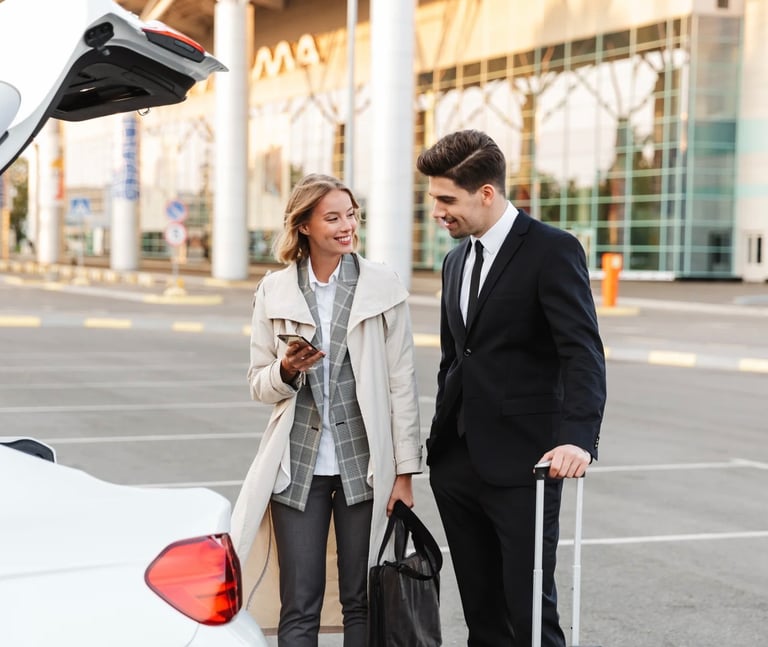 a man and woman standing in front of a car