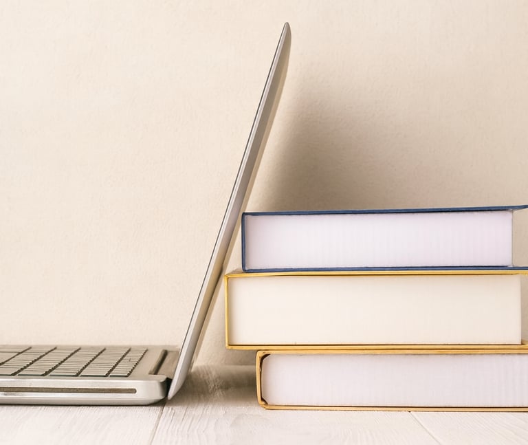A laptop leaning against some books