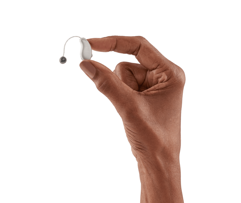 Pessoa segurando uma aparelho auditivo discreto na mão