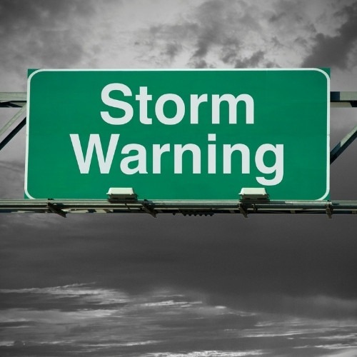 storm warning sign with storm clouds in the background