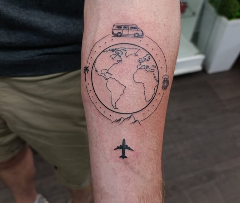 Man's arm tattoo of a plane flying over a globe.  Tattooed at Katarsis Studio in Lima