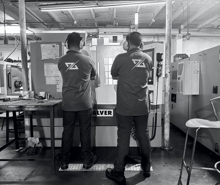 Maquina de mecanizado cnc en las instalaciones de Holimpus SAS con dos trabajadores supervisando