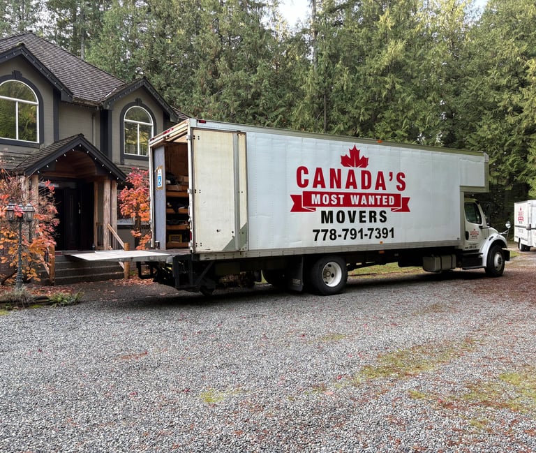 Canada’s Most Wanted Movers truck parked at a forest-side home in the Lower Mainland during a residential move.