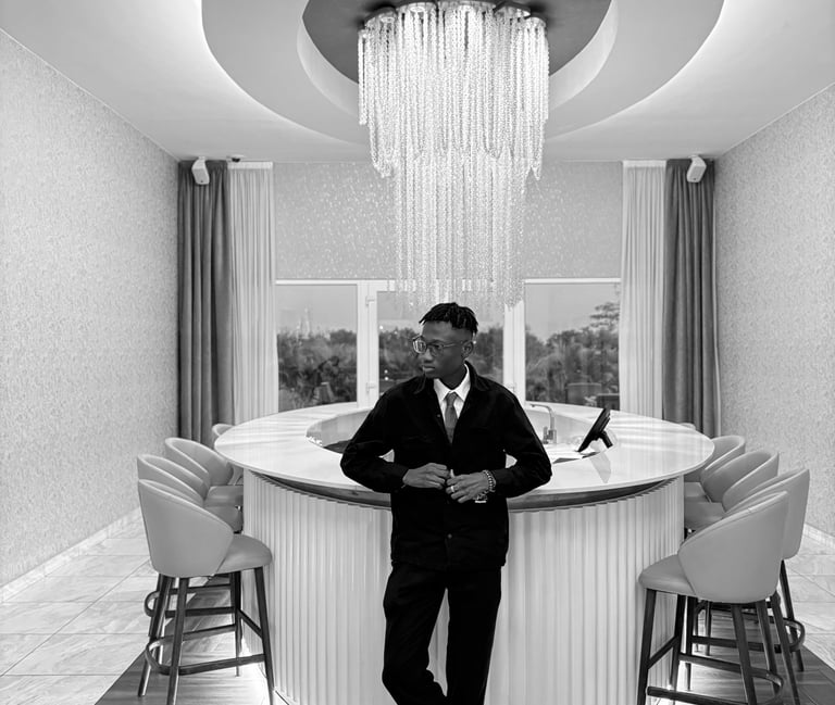 reed in a suit and tie standing infront of a bar