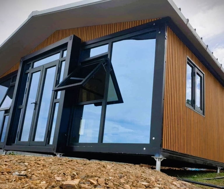 Tiny house modulaire moderne avec bardage bois et grandes baies vitrées.