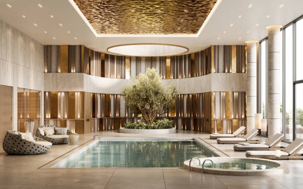 Sala de estar con una piscina en el centro. Paneles dorados en la pared y una gran planta frente a e
