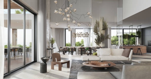 Sala de estar con grandes ventanales, sofá blanco y un sillón de madera marrón en el centro de la im