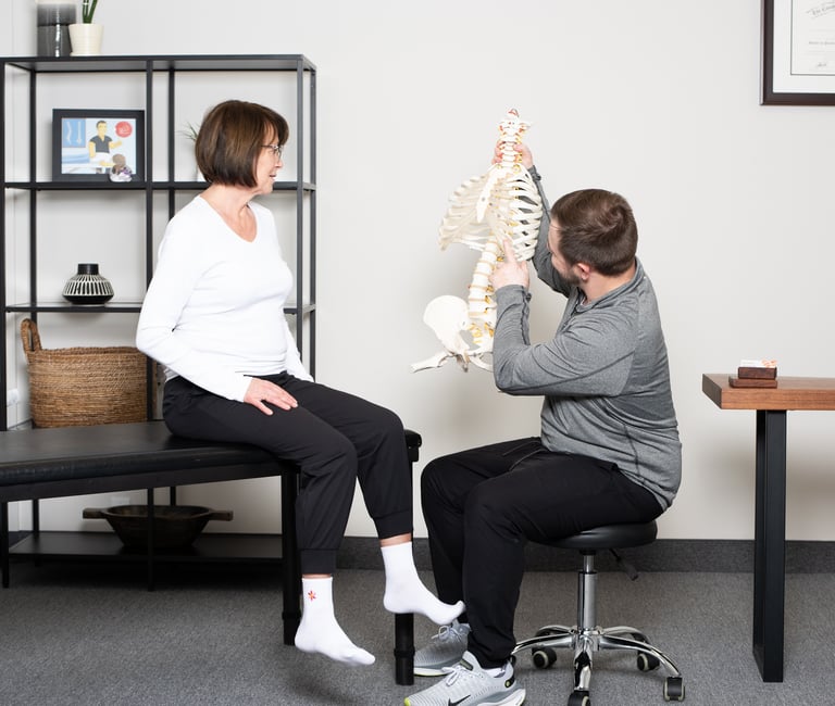 Osteopathic practitioner educating the patient on the spine  