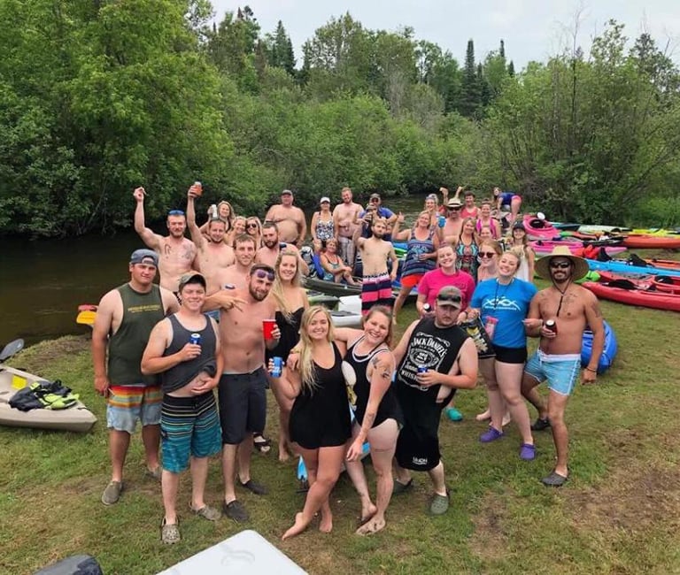 a group of people standing around a group of kayaks