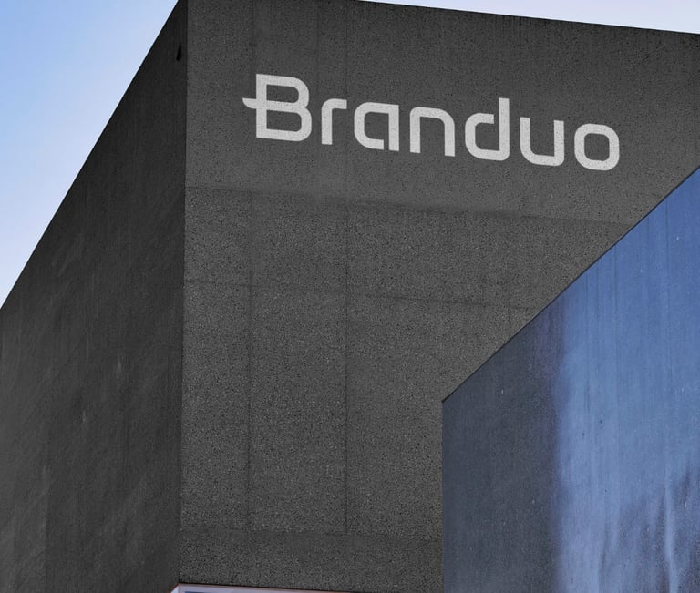 Fachada do Estúdio Criativo Branduo, com textura de cimento cinza escuro e letreiro em branco.