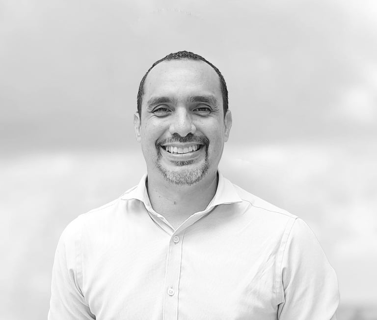 un hombre con camisa blanca sonriendo en foto blanco y negro