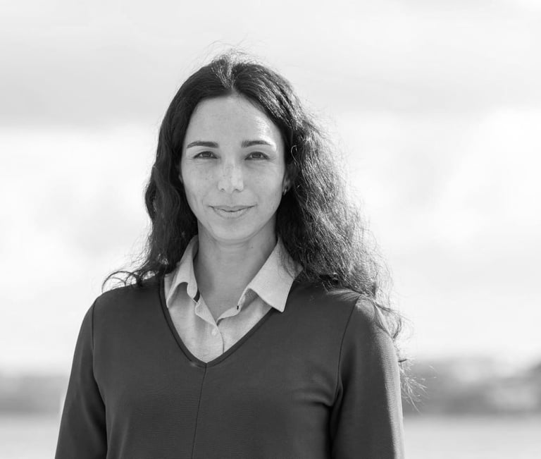 una mujer sonriendo y mirando a la cámara en foto blanco y negro
