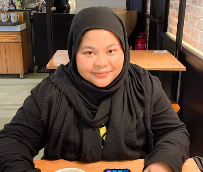 Female in black shirt and hijab in a cafe