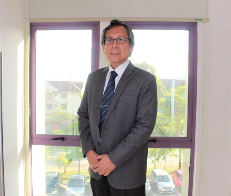 A man in suit standing in front of glass windows