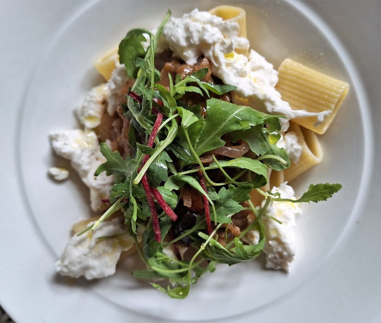 a plate of pasta with cheese and vegetables