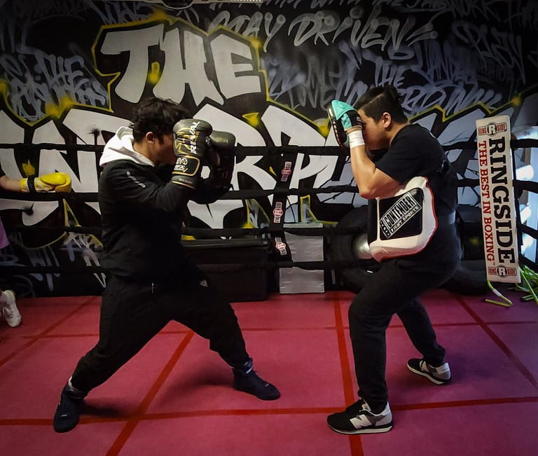 tough student and coach philip engaged in advanced pad work training in the boxing ring