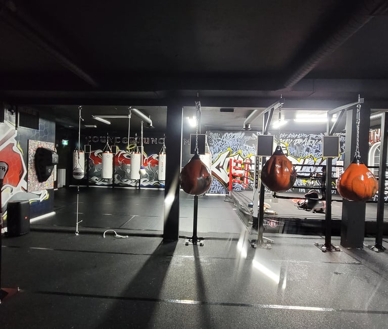 wide-shot of the counterpunch boxing club featuring boxing ring, heavy punching bags, and reflex bags