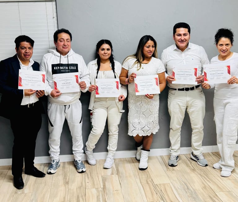 A group of smiling graduates posing together while holding their professional certification awards.