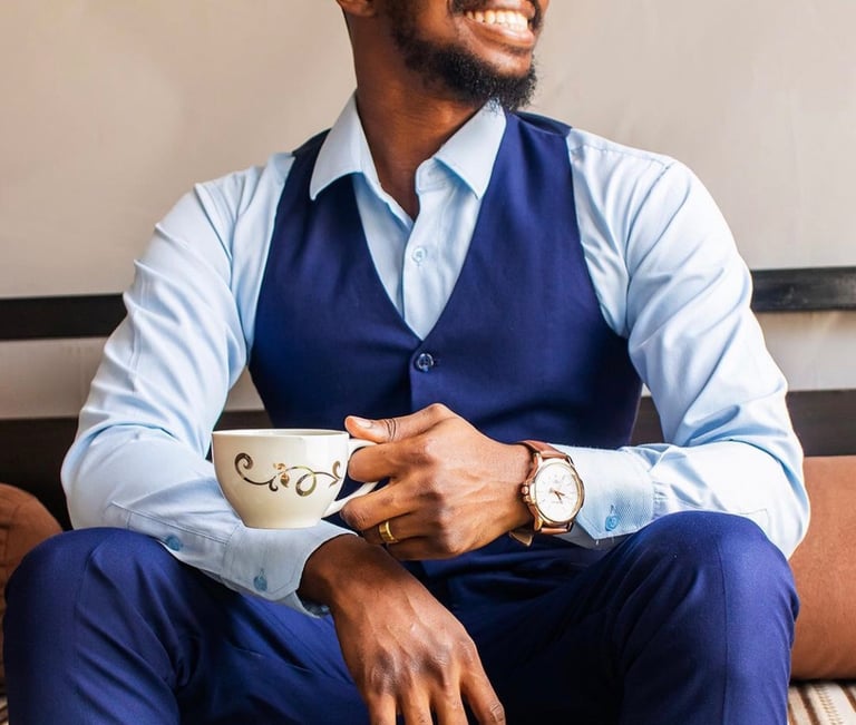 A man wearing a blue formal wear holding a cup of coffee