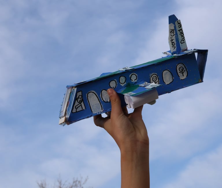 photo of Childs hand holding up cardboard airplane