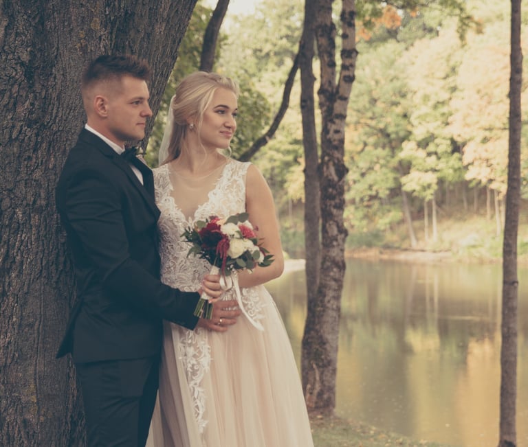 Romantiška nuotrauka, kurioje jaunavedžiai žvelgiantys kryptingai į vieną pusę