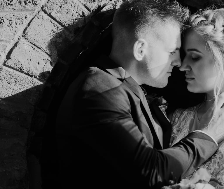 Nespalvota jaunavedžių nuotrauka, vyras švelniai glosto savo žmoną