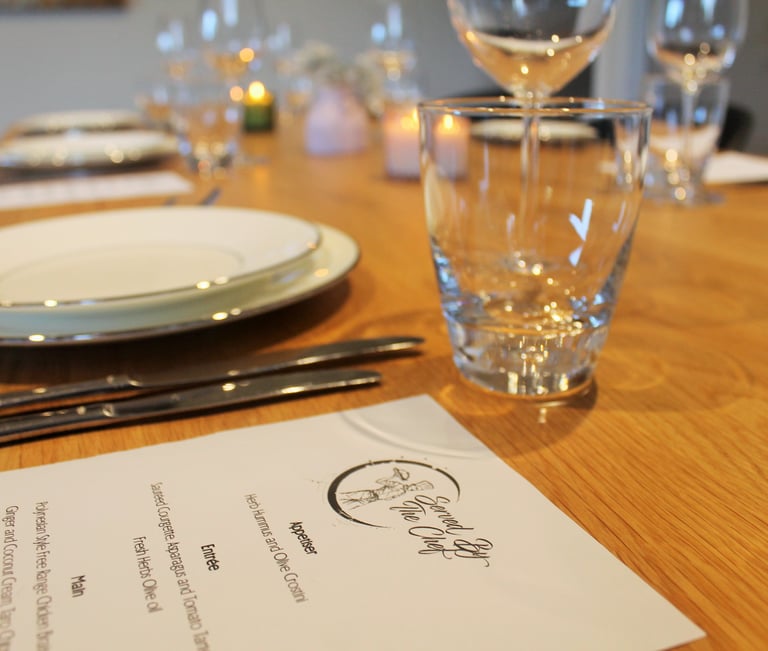 a table with a menu card and wine glasses