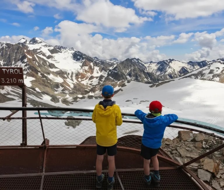 Two kids at Top of Tyrol 3210m mountain viewpoint, Stubai Glacier Alps.