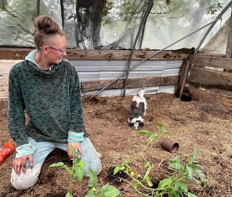 photo of Kia Beth with Cricket the dog in the greenhouse