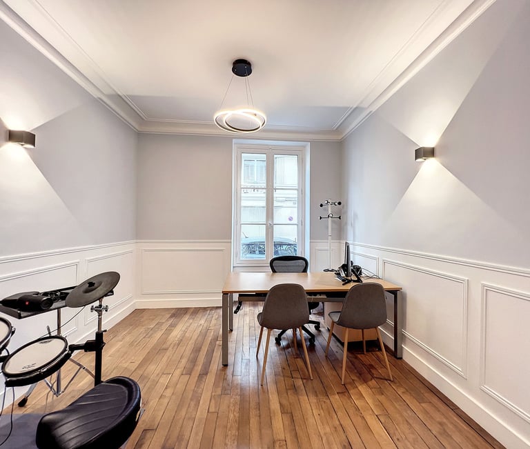 a room with a table and chairs and a drum set up