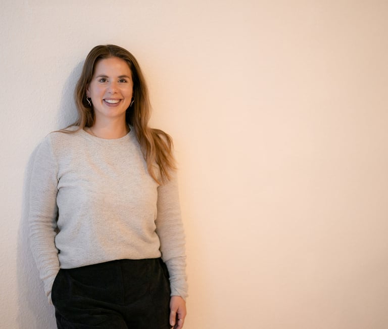 Frau lehnt an der Wand und stellt sich als kompetente Beraterin vor