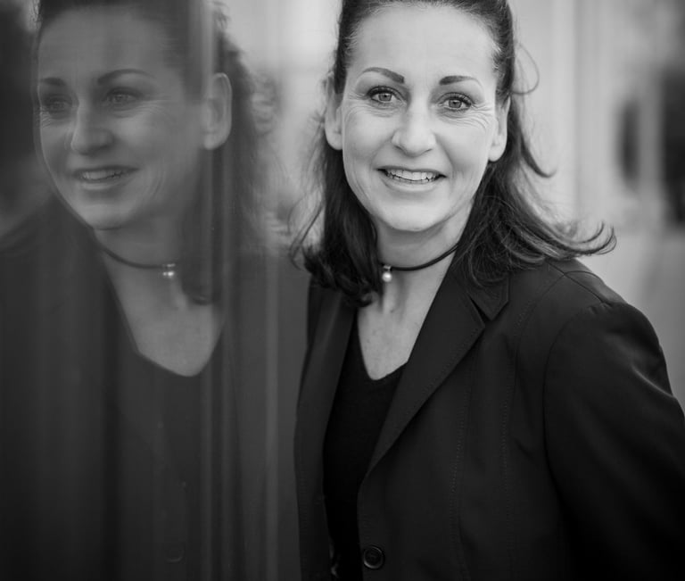 a woman in a black jacket and glasses