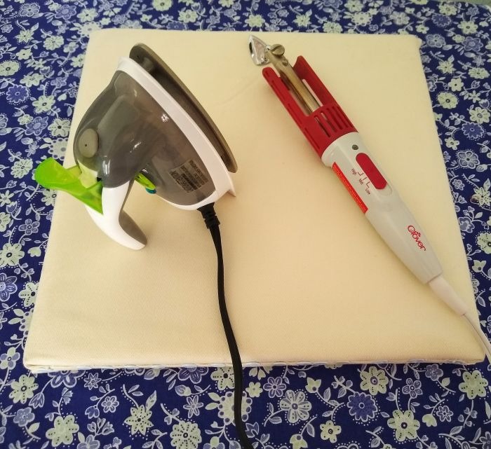 "DIY portable ironing board with a mini steam iron and a Clover craft iron resting on top, displayed