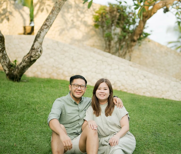 Couple sitting together in a tropical garden during a family photography session in Bali.