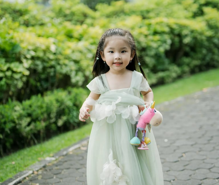 Young girl walking through a tropical resort garden during a family photography session in Bali.