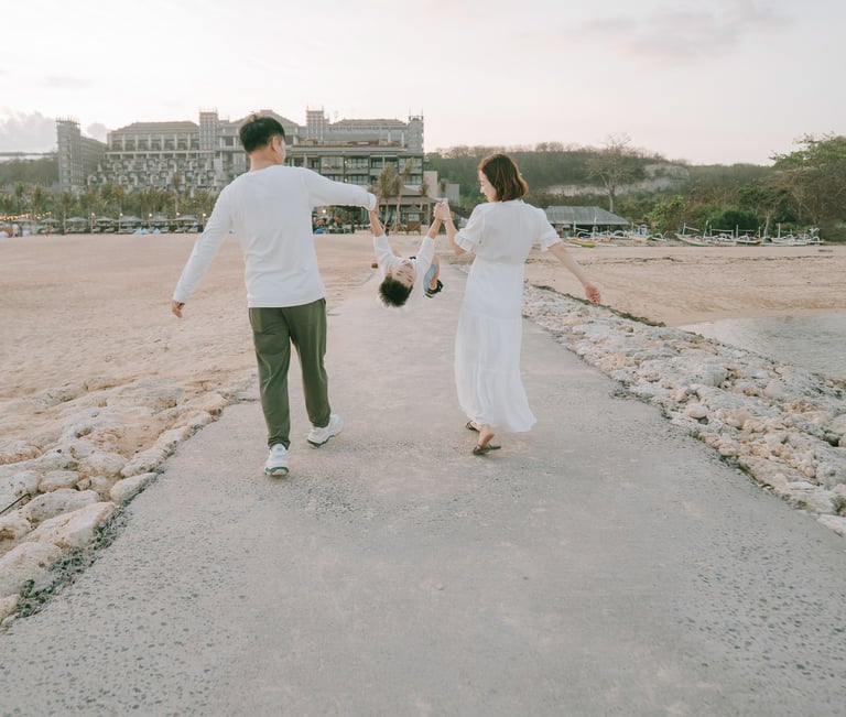 Family walking along the seaside pathway during a family photography session at The Apurva Kempinski Bali.