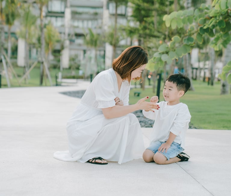 Mother and child interaction captured during a family photography session at The Apurva Kempinski Bali garden area.