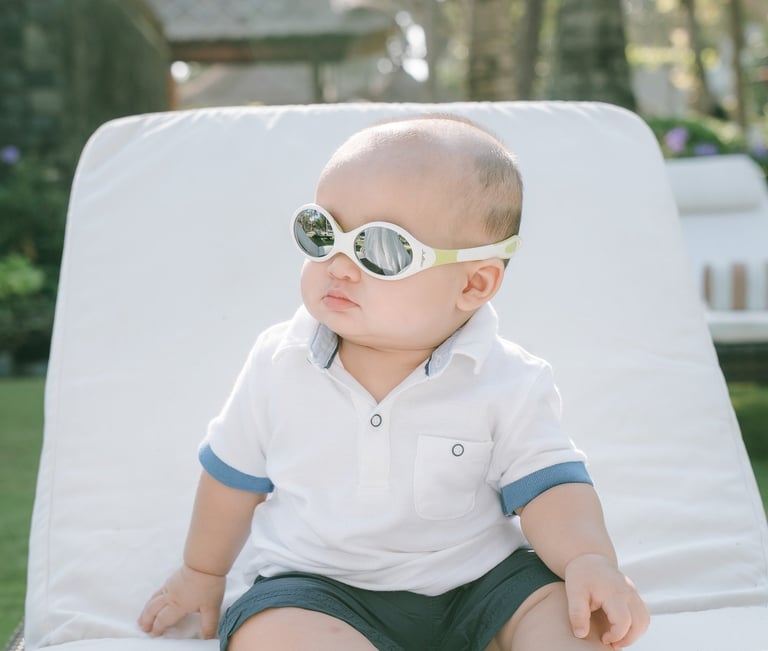 Baby sitting on sunbed at Intercontinental Jimbaran captured in a soft and playful family photography moment