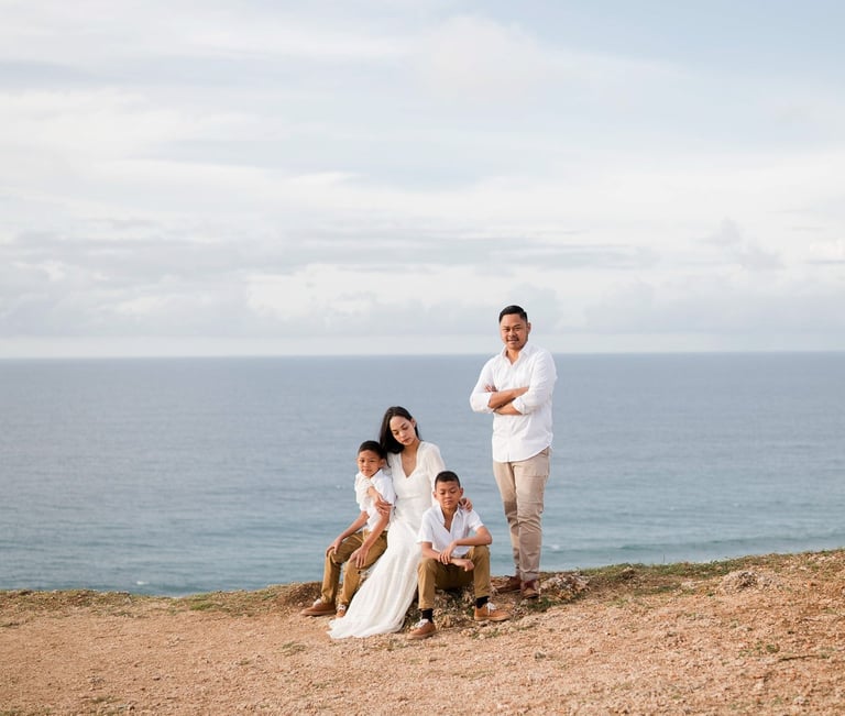 Wide cliffside view of Ayunda family enjoying the ocean backdrop at Melasti Beach Bali.