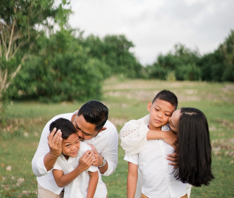 Intimate moment of Ayunda family embracing at Melasti Beach Bali.