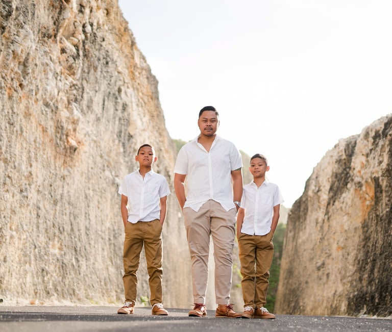 Family portrait of Ayunda family standing along the limestone cliffs at Melasti Beach Bali.