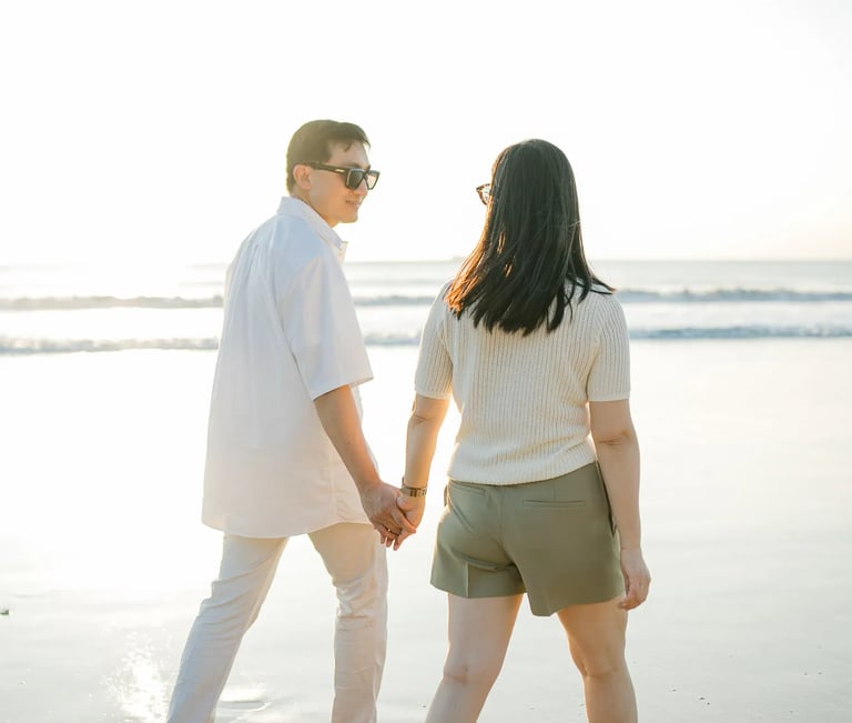 Family walking hand in hand on the beach at InterContinental Bali Resort during sunset
