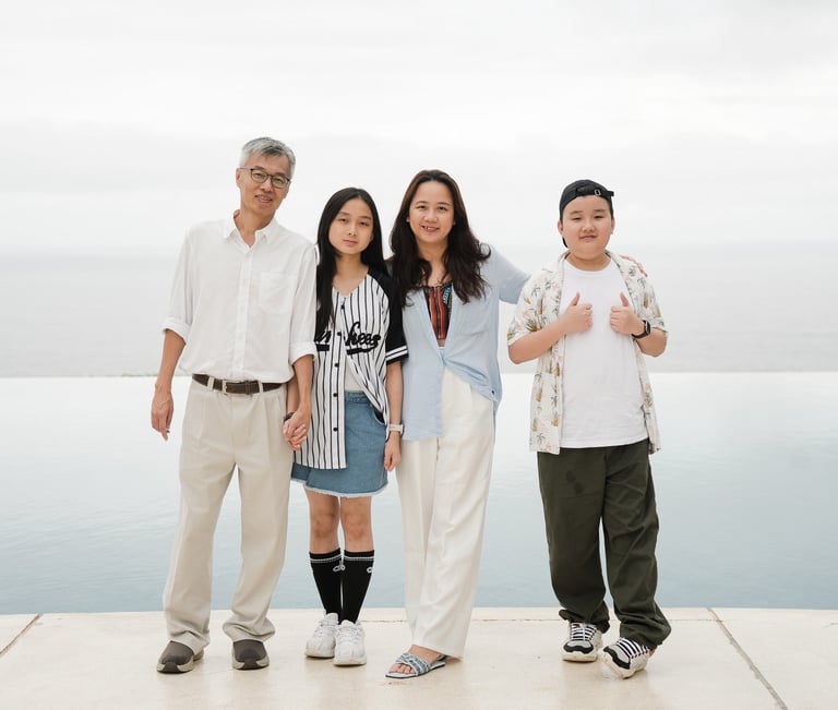 Family portrait near infinity edge pool at Alila Villas Uluwatu Bali with calm ocean backdrop
